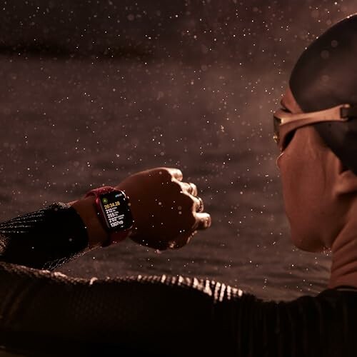 Swimmer wearing goggles checks smartwatch in water